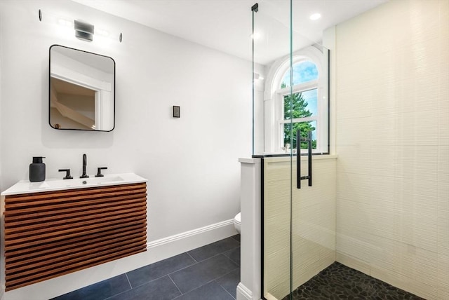 full bath featuring vanity, baseboards, a stall shower, tile patterned flooring, and toilet