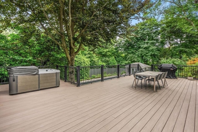wooden terrace featuring outdoor dining space and a hot tub