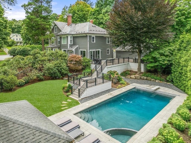 outdoor pool featuring stairway, a wooden deck, an in ground hot tub, a diving board, and a lawn