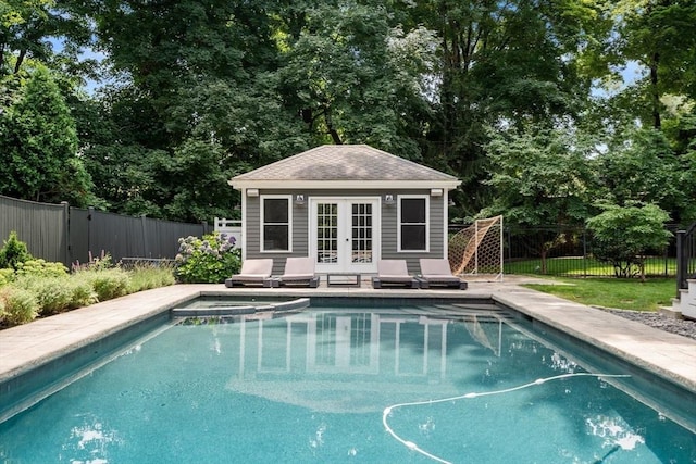 view of pool with an outdoor structure, a storage structure, fence private yard, and a pool with connected hot tub