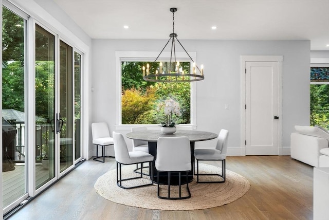dining area with a notable chandelier, light wood-style floors, recessed lighting, and baseboards