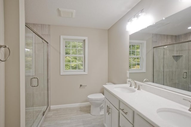 full bath with toilet, a shower stall, baseboards, and a sink