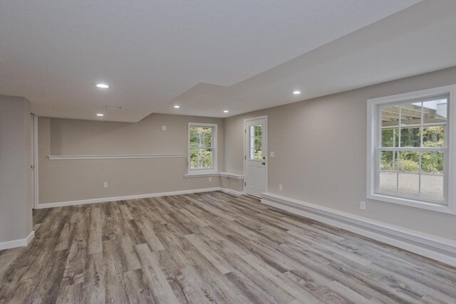 empty room with baseboards, wood finished floors, and recessed lighting