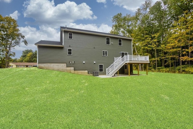 rear view of house with central AC, a yard, a deck, and stairway