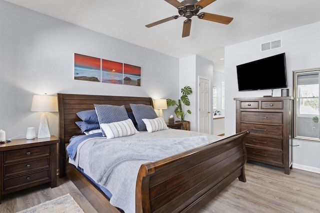 bedroom featuring light wood-style floors, visible vents, and a ceiling fan