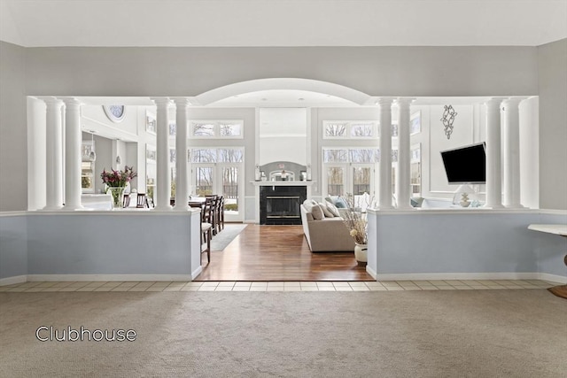 living room featuring a fireplace, carpet flooring, and ornate columns