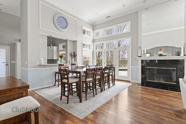 dining area with a wealth of natural light, hardwood / wood-style floors, and a tile fireplace