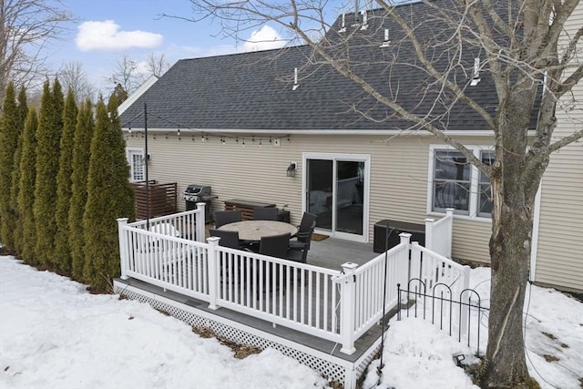 snow covered rear of property featuring roof with shingles and a wooden deck