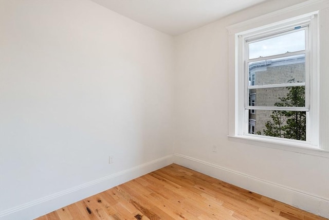 empty room with light wood finished floors and baseboards