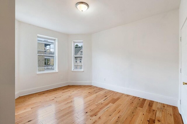 unfurnished room featuring baseboards and light wood finished floors