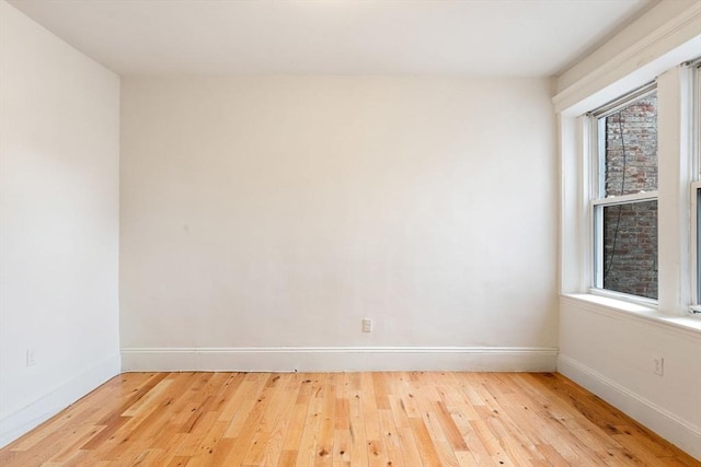 unfurnished room with hardwood / wood-style flooring and baseboards