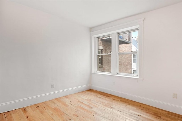 spare room featuring hardwood / wood-style floors and baseboards