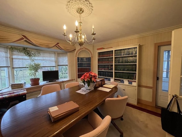 dining space with crown molding and an inviting chandelier