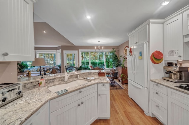 kitchen featuring white fridge, white cabinetry, light hardwood / wood-style flooring, and an inviting chandelier