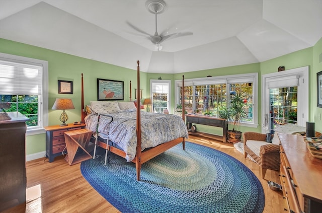 bedroom featuring ceiling fan, access to outside, multiple windows, and light hardwood / wood-style floors