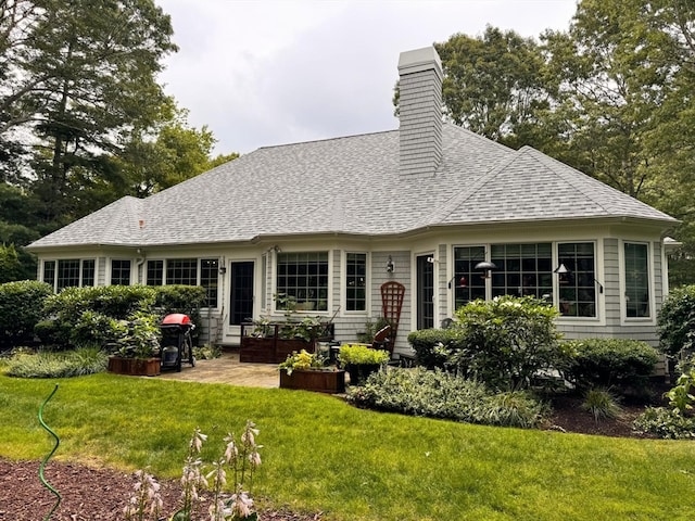 rear view of house featuring a yard