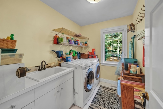 laundry room featuring sink, washer and dryer, light tile patterned floors, and cabinets