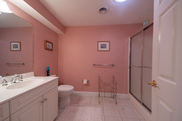 bathroom with vanity, tile patterned flooring, toilet, and walk in shower