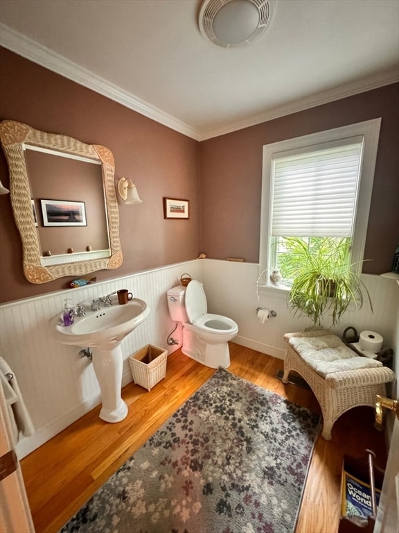 bathroom with toilet, wood-type flooring, and ornamental molding