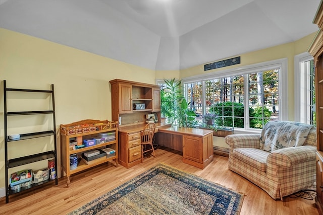 home office featuring light wood-type flooring and vaulted ceiling