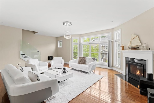 5 Manor Dr Unit B, Hooksett, NH 03106 - living room featuring wood-type flooring, a fireplace with flush hearth, baseboards, and a chandelier
