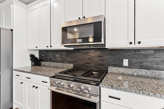 5 Manor Dr Unit B, Hooksett, NH 03106 - kitchen featuring appliances with stainless steel finishes, light stone countertops, white cabinetry, and decorative backsplash