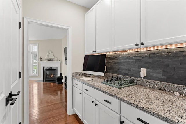 5 Manor Dr Unit B, Hooksett, NH 03106 - kitchen with decorative backsplash, wood finished floors, light stone counters, and white cabinets