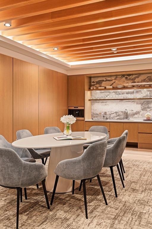 dining area featuring wooden ceiling, bar area, and wood walls