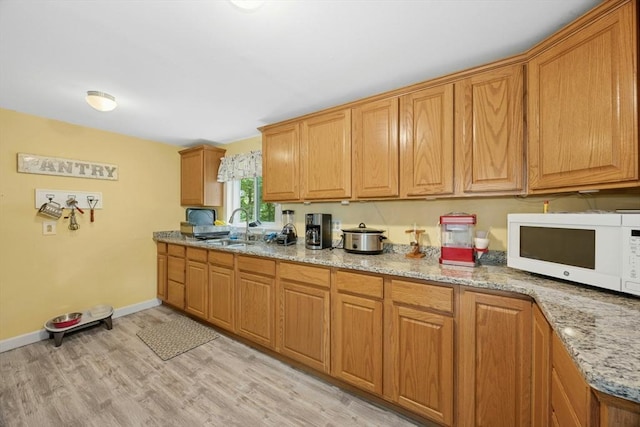 8 Stones Corner Rd, Berlin, MA 01503 - kitchen with white microwave, light wood-style flooring, light stone countertops, and brown cabinetry