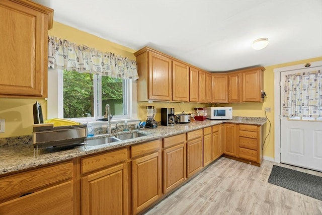 8 Stones Corner Rd, Berlin, MA 01503 - kitchen with light wood-style floors, light stone countertops, white microwave, and brown cabinetry