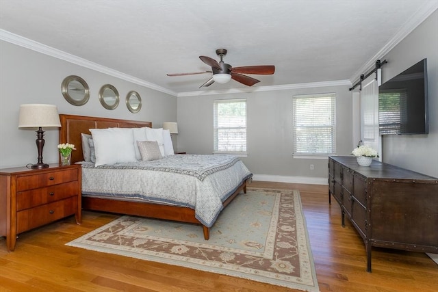 bedroom with crown molding, baseboards, ceiling fan, and wood finished floors