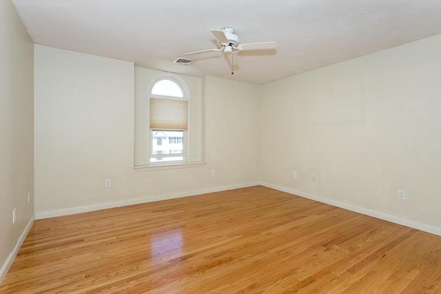 unfurnished room featuring visible vents, light wood finished floors, ceiling fan, and baseboards