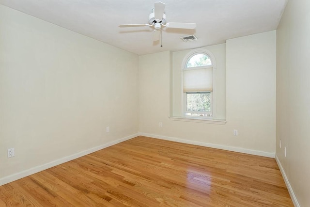 spare room featuring visible vents, light wood-style flooring, ceiling fan, and baseboards