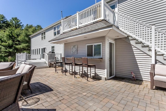 view of patio / terrace featuring stairs and a balcony