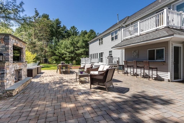 view of patio featuring a balcony, outdoor dry bar, and outdoor dining space