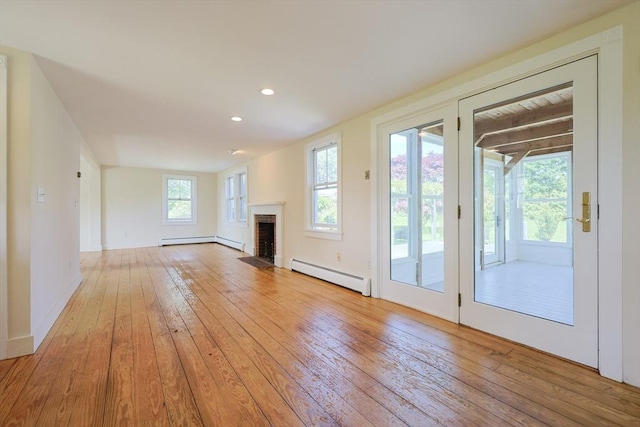 460 W Main Rd, Little Compton, RI 02837 - unfurnished living room featuring baseboard heating, light wood-type flooring, a baseboard heating unit, recessed lighting, and a brick fireplace