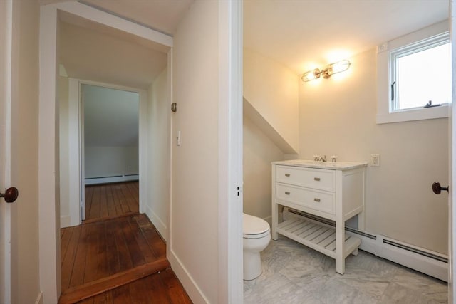 460 W Main Rd, Little Compton, RI 02837 - bathroom with a baseboard heating unit, toilet, vanity, hardwood / wood-style flooring, and baseboards