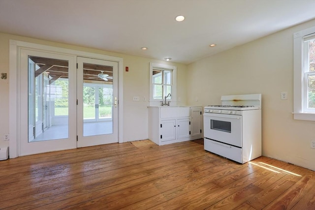 460 W Main Rd, Little Compton, RI 02837 - kitchen with white gas range oven, healthy amount of natural light, white cabinets, a sink, and recessed lighting