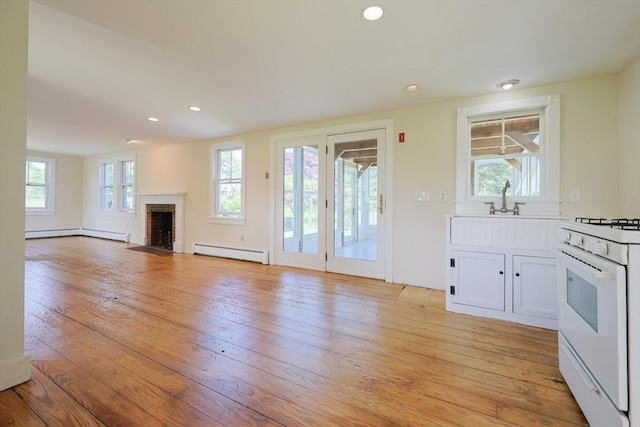 460 W Main Rd, Little Compton, RI 02837 - unfurnished living room featuring a baseboard radiator, a fireplace, a baseboard heating unit, light wood finished floors, and recessed lighting