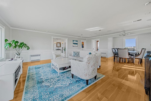 75 Point Allerton Ave, Hull, MA 02045 - living area with radiator, ornamental molding, a decorative wall, light wood-type flooring, and a wainscoted wall
