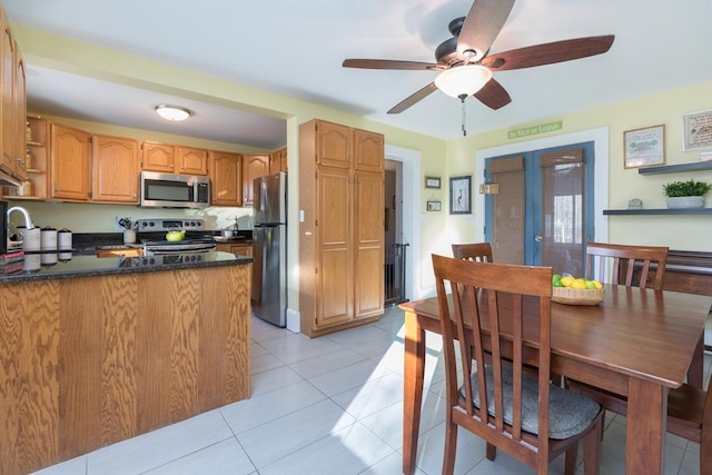 kitchen with ceiling fan, light tile patterned floors, appliances with stainless steel finishes, a peninsula, and a sink