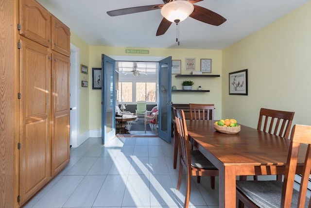 dining room with light tile patterned flooring, baseboards, and ceiling fan