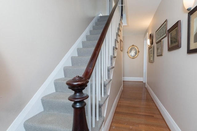 stairway featuring wood finished floors and baseboards