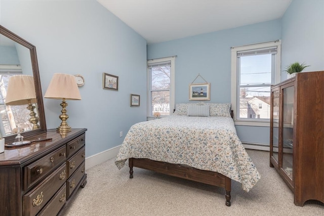 bedroom featuring a baseboard radiator, multiple windows, light colored carpet, and baseboards