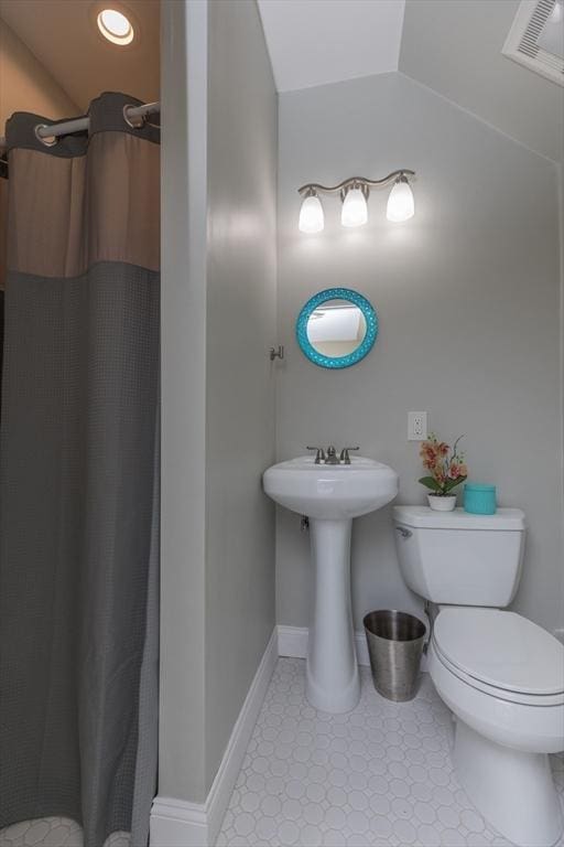 bathroom featuring a shower with curtain, baseboards, visible vents, lofted ceiling, and toilet