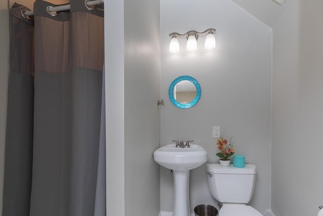 bathroom featuring curtained shower and toilet