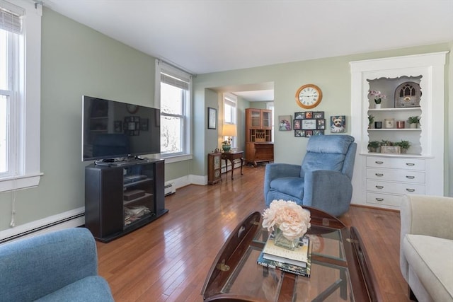 living area with a baseboard radiator and wood-type flooring