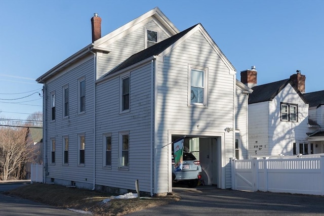 view of front of home with a gate, fence, and a chimney