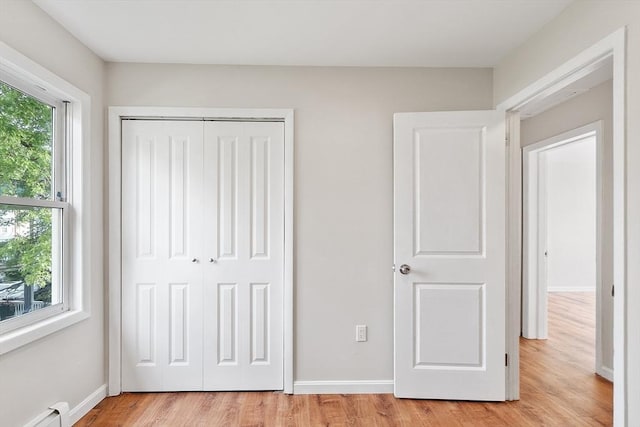 2 Howe Ter Unit 11, Boston, MA 02125 - unfurnished bedroom with baseboard heating, light wood finished floors, a closet, and baseboards
