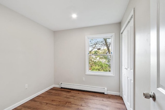 2 Howe Ter Unit 11, Boston, MA 02125 - unfurnished bedroom featuring a baseboard heating unit, wood finished floors, baseboards, a closet, and recessed lighting